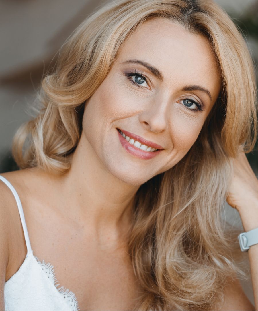 Smiling woman with blonde hair and soft makeup.