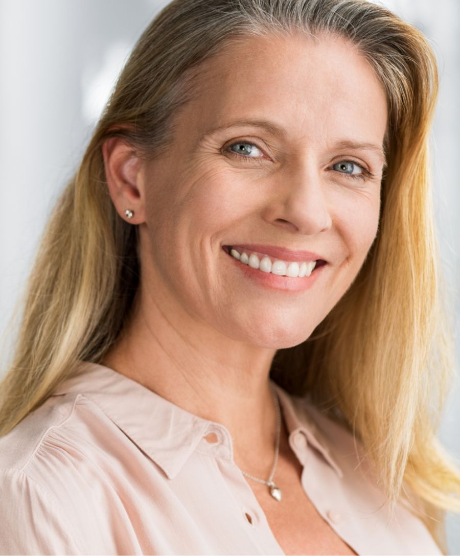 Smiling woman with long blonde hair and earrings.