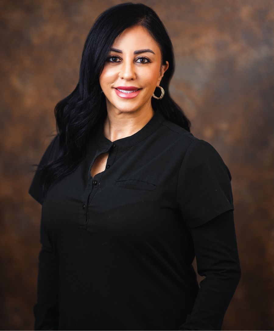 Professional woman smiling against a brown backdrop.