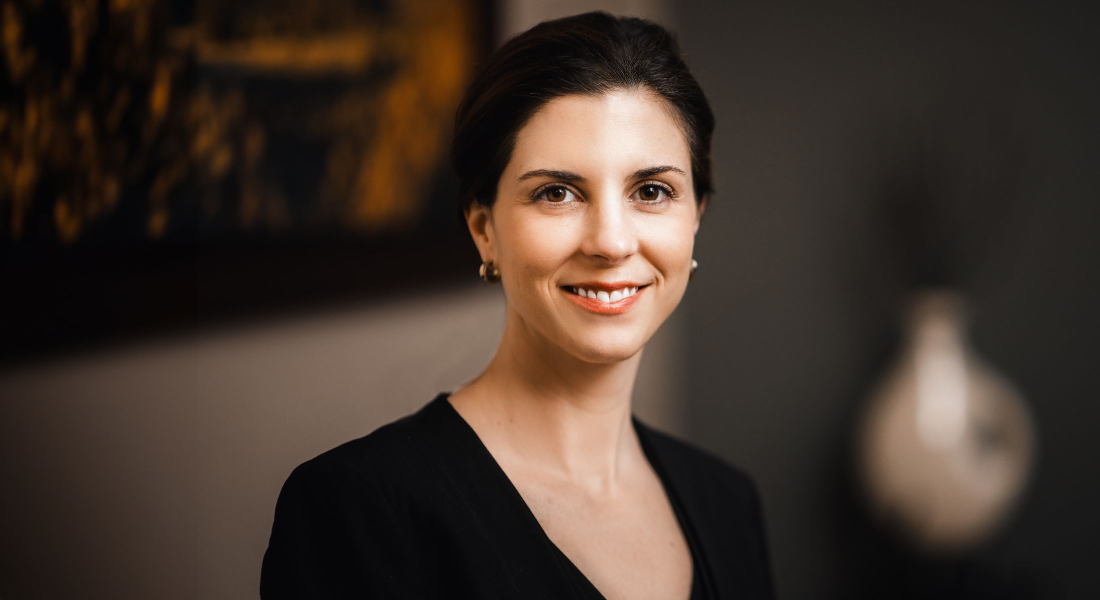 Woman smiling in professional setting, soft background.